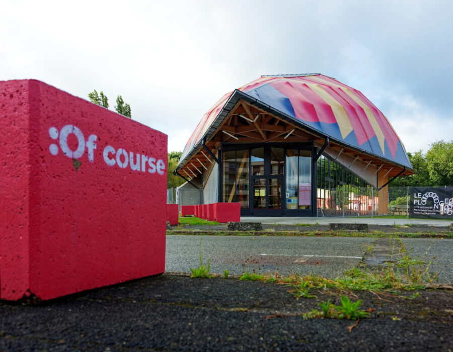 Entrée du chapiteau permanent de la Cité du Cirque et bloc béton de sécurité rouge 